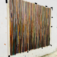 Abstract art piece with vertical brush strokes on a white wall.