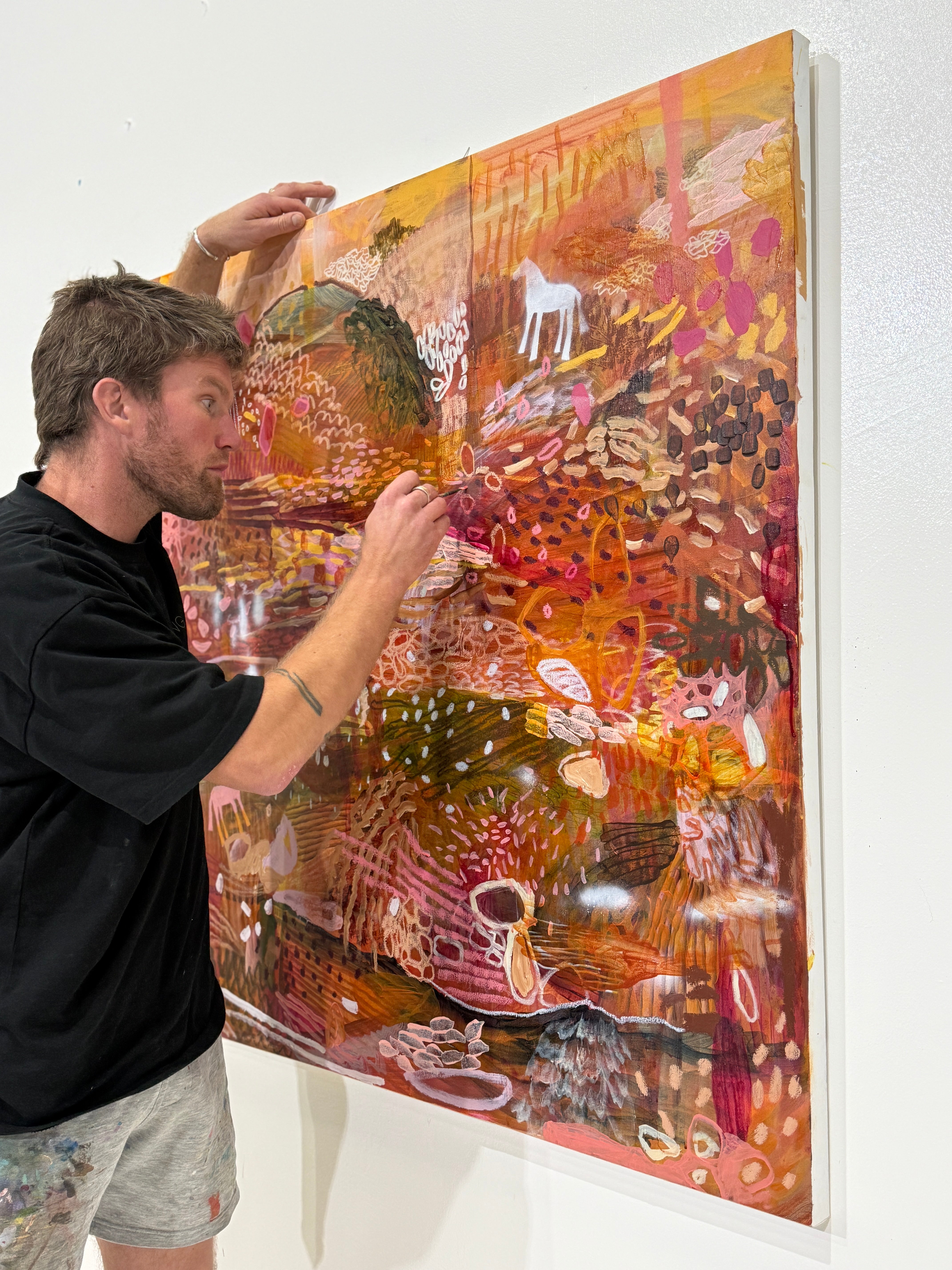 JWG  adjusting a large abstract painting on a white wall